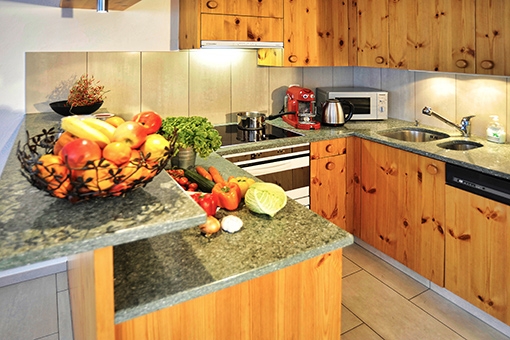 Wohnzimmer mit integrierter Küche Küche - Ferienwohnung Lakeside in Laax